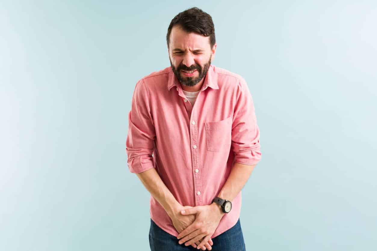 Pained man suffering from health issues and urinary incontinence. Latin man with a bladder infection