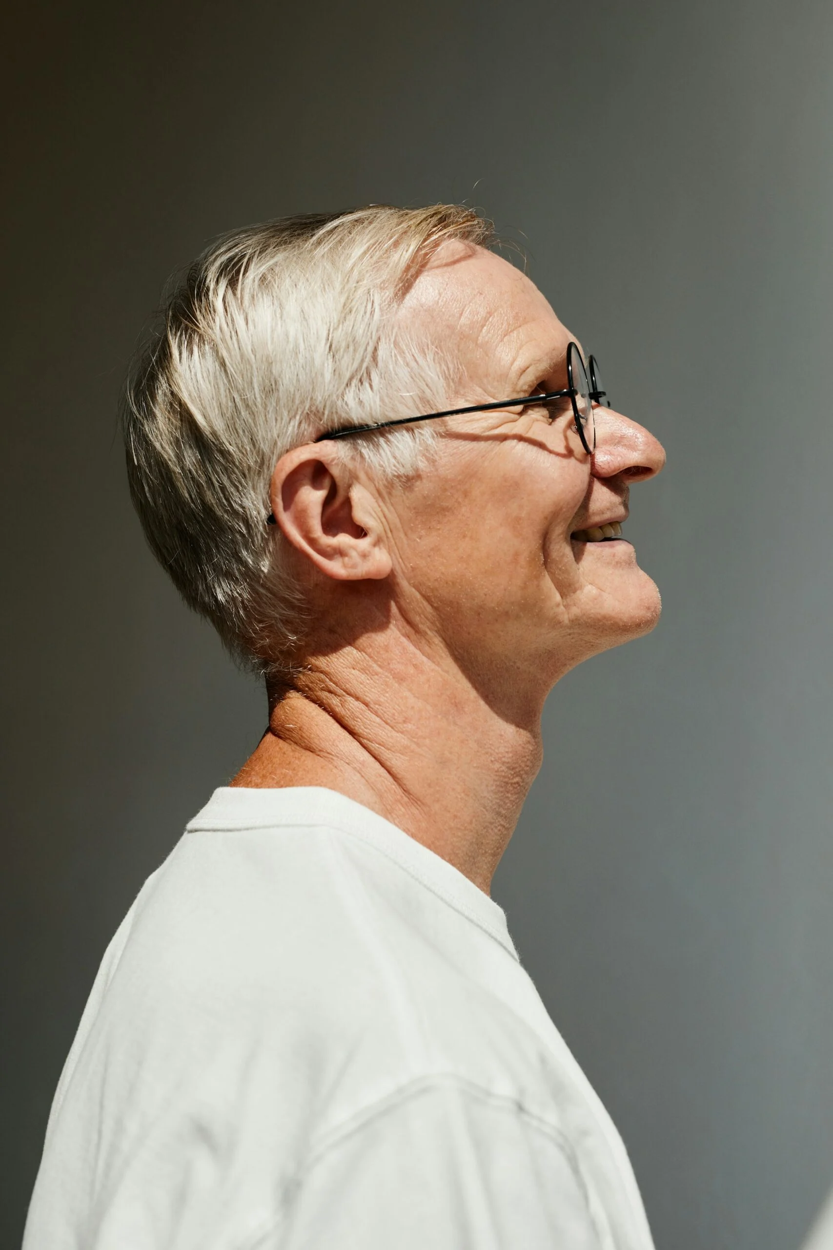 A man in his seventies, listening, in profile.