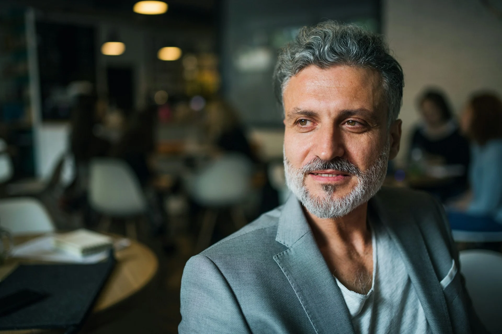 The founder, photographed in a cafe, looking directly at the camera